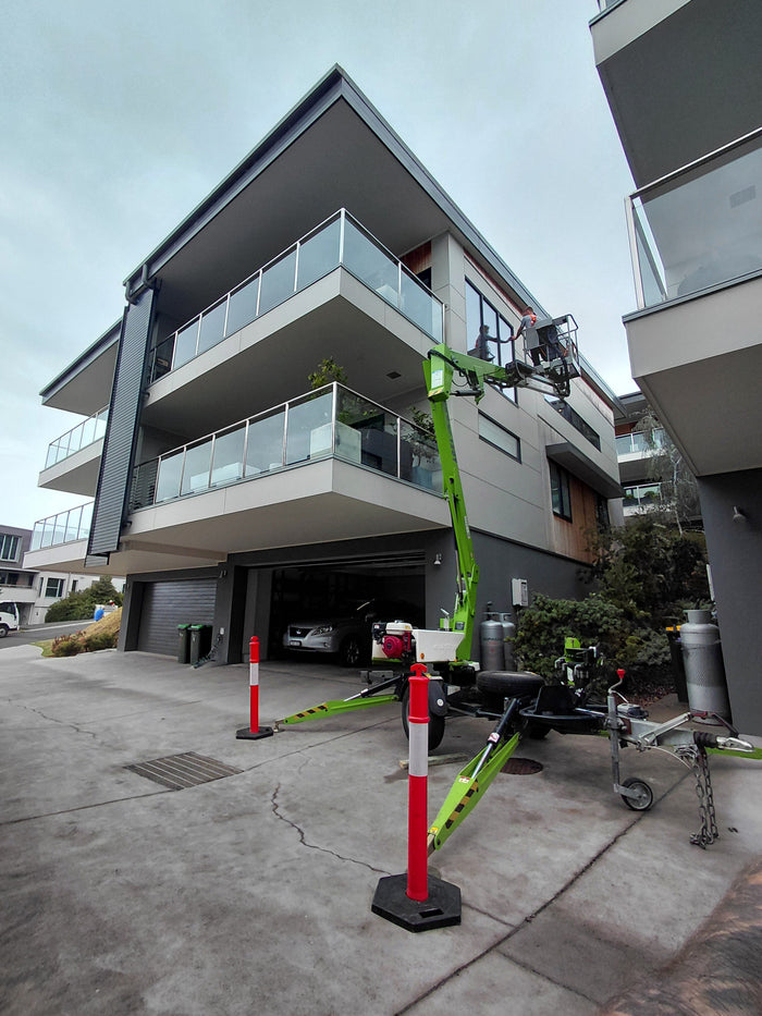 Trailer mounted elevated work platform reaching a third storey window in Lorne
