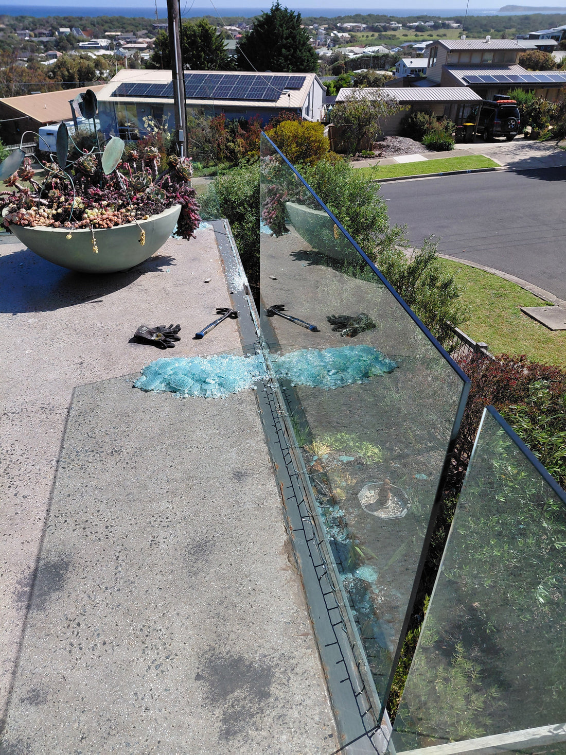 Shattered toughened balustrade glass across a balcony deck after a panel broke on its own