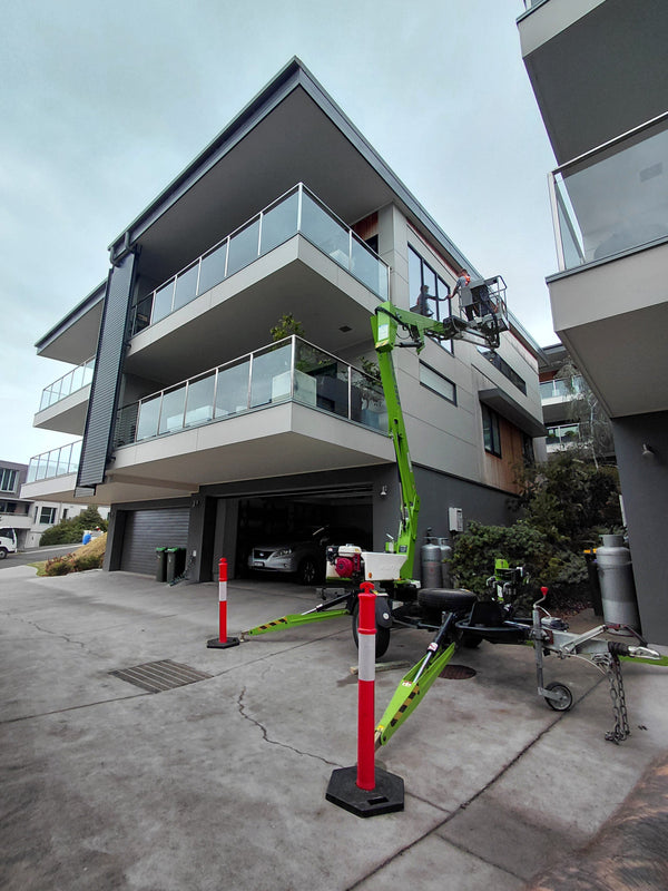 Trailer mounted elevated work platform reaching a third storey window in Lorne