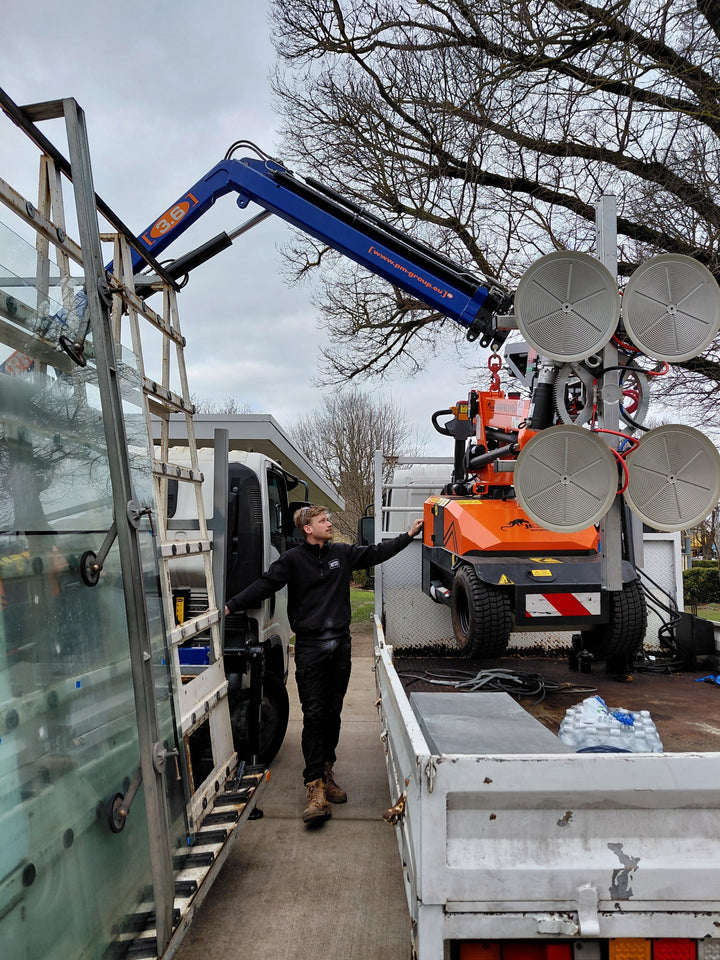 Glass panels on the truck rack beside the Jekko MPK06 vacuum lifter at a Colac job