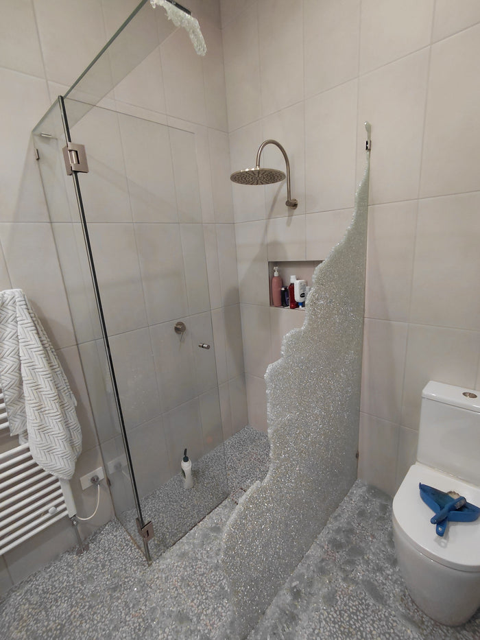 Shattered toughened side panel of a corner shower screen in Newtown with glass across the bathroom floor