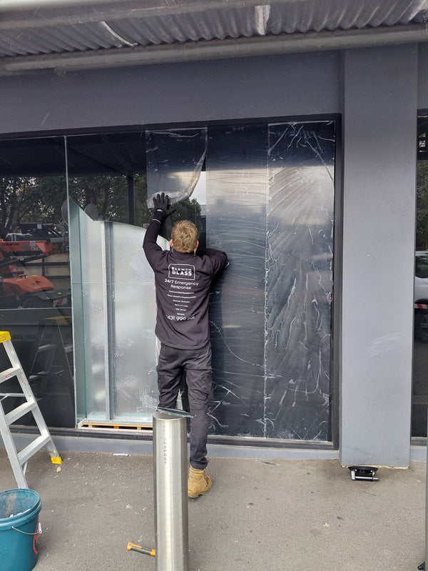 Peeling back the dark tint film that was holding a cracked float glass shopfront together at NAB Geelong West