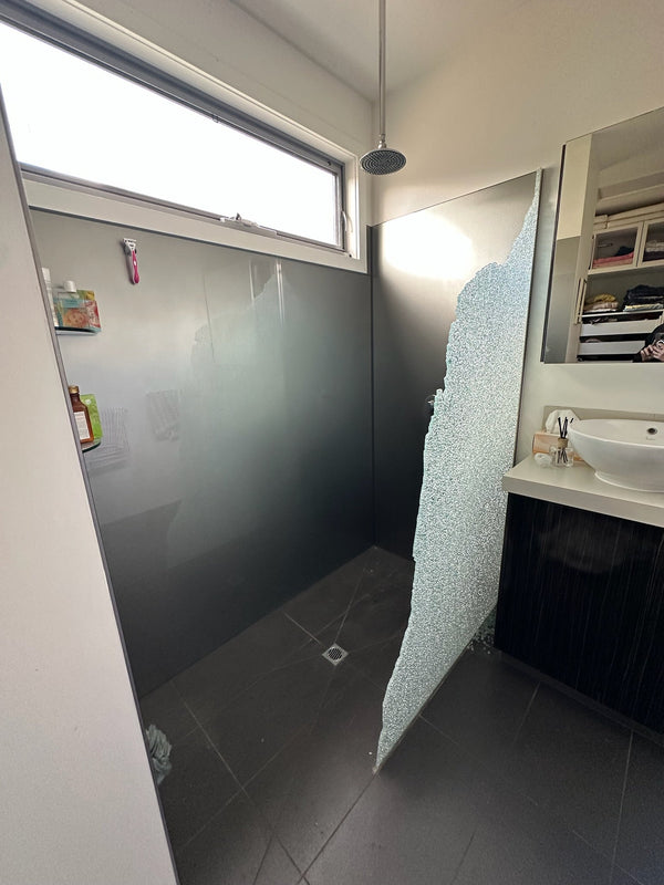 Shattered toughened shower screen panel still standing in place in a Torquay bathroom
