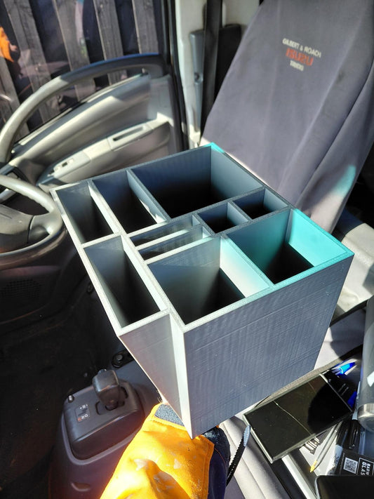 ISUZU N Series wide cab centre seat organizer held up in the truck cab, showing the multi-compartment 3D printed design